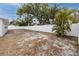 Backyard of the newly renovated house with a white fence and sandy ground at 7449 16Th N St, St Petersburg, FL 33702