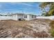 Backyard of the newly renovated house with a white fence and sandy ground at 7449 16Th N St, St Petersburg, FL 33702