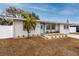 Newly renovated house with light gray exterior, teal front door, and landscaped front yard at 7449 16Th N St, St Petersburg, FL 33702