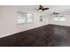 Spacious living area with dark laminate flooring and two ceiling fans at 7449 16Th N St, St Petersburg, FL 33702