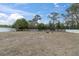 Empty lot with a white fence and mature trees at 8237 Delaware Dr, Weeki Wachee, FL 34607