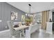 Elegant dining room with farmhouse table and gray accent wall at 8237 Delaware Dr, Weeki Wachee, FL 34607