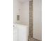 Shower with white tile and a pebble stone accent wall at 9057 Bantry Bay Blvd, Englewood, FL 34224