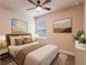 Bedroom with queen bed, brown bedding, and ceiling fan at 9057 Bantry Bay Blvd, Englewood, FL 34224