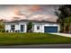 White one-story house with a blue garage door and manicured lawn at 9057 Bantry Bay Blvd, Englewood, FL 34224