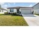 Curb appeal abounds in this charming one-story home featuring a gray garage door and well-manicured lawn at 9215 Royal River Cir, Parrish, FL 34219