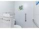 Small bathroom with toilet, grab bars, and a wall-mounted shelf at 1018 Caravel Ct, Tarpon Springs, FL 34689