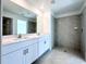 Modern bathroom with double vanity, large mirror, and walk-in shower at 105 Oakwood Ct, Rotonda West, FL 33947