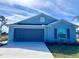 Newly built home with a gray garage door and blue exterior at 105 Oakwood Ct, Rotonda West, FL 33947