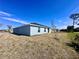 Rear view of single-story home, showcasing backyard and landscaping at 105 Oakwood Ct, Rotonda West, FL 33947