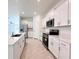 Modern kitchen with white cabinets, quartz countertops and stainless steel appliances at 105 Oakwood Ct, Rotonda West, FL 33947