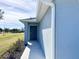 Side view of a light blue house with gray door and walkway at 105 Oakwood Ct, Rotonda West, FL 33947