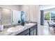 Double vanity bathroom with granite countertop and view of home office at 10535 Bridgegate Heights Loop, San Antonio, FL 33576