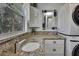 Bathroom boasts granite countertop, modern sink and stacked washer/dryer at 10581 Pine Island Dr, Weeki Wachee, FL 34607