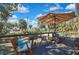 Outdoor deck with seating area and shaded umbrella, overlooking nature at 10581 Pine Island Dr, Weeki Wachee, FL 34607