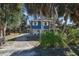 Front view of charming blue house with tropical landscaping at 10581 Pine Island Dr, Weeki Wachee, FL 34607