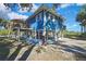 Back view of a blue house with elevated deck and carport at 10581 Pine Island Dr, Weeki Wachee, FL 34607