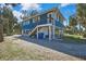 Side view of blue house, showing deck, stairs, and carport at 10581 Pine Island Dr, Weeki Wachee, FL 34607