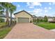 House with a two-car garage and brick driveway at 10804 Wicker Park Pl, Palmetto, FL 34221