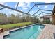 Inviting screened pool with spa and lush landscaping at 10804 Wicker Park Pl, Palmetto, FL 34221