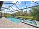 Inviting pool and spa with a screened enclosure, surrounded by lush landscaping at 10804 Wicker Park Pl, Palmetto, FL 34221