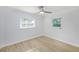 Well-lit bedroom featuring wood-look floors and two windows at 10821 Freedom Blvd, Seminole, FL 33772