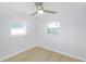 Simple bedroom with wood-look floors and two windows at 10821 Freedom Blvd, Seminole, FL 33772