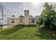 Rear view of the house showcasing a chimney and lawn at 10821 Freedom Blvd, Seminole, FL 33772