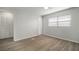 Well-lit bedroom featuring wood-look floors and double doors at 1203 Baronwood Pl, Brandon, FL 33510