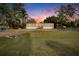 Mobile home at sunset with a fenced yard and tree-lined street at 12914 Gordon Rd, Riverview, FL 33579