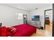 Bedroom with red bedding, dresser, and a view of the living room at 13178 Thrush St, Spring Hill, FL 34609