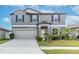 Two-story house with gray siding, neutral garage door, and landscaped lawn at 13614 Wild Ginger St, Riverview, FL 33579