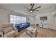 Bright living room with a blue sofa, wood-look floors, and a large TV at 1415 Mohrlake Dr, Brandon, FL 33511