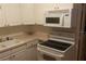 White cabinets, microwave, and electric stove top at 1601 Essex N Dr, St Petersburg, FL 33710