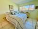 Comfortable bedroom with a striped comforter and large window at 1701 Pinehurst Rd # 8B, Dunedin, FL 34698