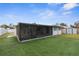 Artificial turf backyard with screened patio and wooden fence at 1807 W Crawford St, Tampa, FL 33604