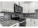 Sleek kitchen with granite countertops and black and white tile backsplash at 1807 W Crawford St, Tampa, FL 33604