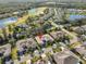 Aerial view of the home showcasing landscaping, a two car garage, and the surrounding neighborhood at 2124 Sifield Greens Way # 11, Sun City Center, FL 33573