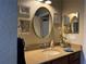 Well-lit bathroom with modern vanity and oval mirror at 2124 Sifield Greens Way # 11, Sun City Center, FL 33573