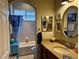 Well-lit bathroom featuring a granite countertop, vanity, decorative mirrors, and tub with shower at 2124 Sifield Greens Way # 11, Sun City Center, FL 33573