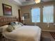 King-size bed, two windows with sheers, and wood furniture at 2124 Sifield Greens Way # 11, Sun City Center, FL 33573