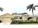 Single-story house with tan exterior, two-car garage, and palm trees at 2124 Sifield Greens Way # 11, Sun City Center, FL 33573