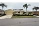 Home exterior featuring a two-car garage, manicured lawn, and lush landscaping at 2124 Sifield Greens Way # 11, Sun City Center, FL 33573