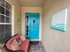 Front porch with teal door, wicker seating, and artwork at 2124 Sifield Greens Way # 11, Sun City Center, FL 33573