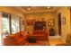 Comfortable living room featuring an orange sectional sofa, tile floors, and lots of natural light at 2124 Sifield Greens Way # 11, Sun City Center, FL 33573