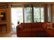 Well-lit living room with an orange sectional sofa and a large sliding glass door to the outside at 2124 Sifield Greens Way # 11, Sun City Center, FL 33573