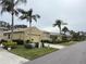 Street view of houses with tan exteriors, palm trees, and landscaping at 2124 Sifield Greens Way # 11, Sun City Center, FL 33573