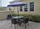 Outdoor brick patio with a dining table, chairs, and a sun umbrella, perfect for entertaining at 2124 Sifield Greens Way # 11, Sun City Center, FL 33573