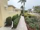 Brick walkway lined with lush green hedges and landscaping at 2124 Sifield Greens Way # 11, Sun City Center, FL 33573