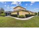 House exterior showcasing a yellow-painted home with a screened-in patio and well-manicured lawn at 2126 Larchwood Ct, Trinity, FL 34655